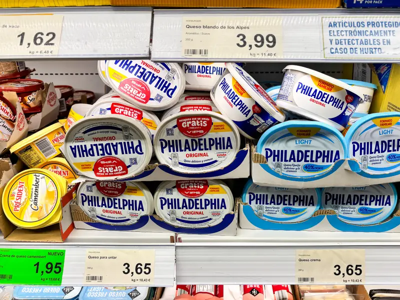 Alicante, Spain - May 27, 2025: Philadelphia cream cheese products stacked on supermarket shelf, showcasing various