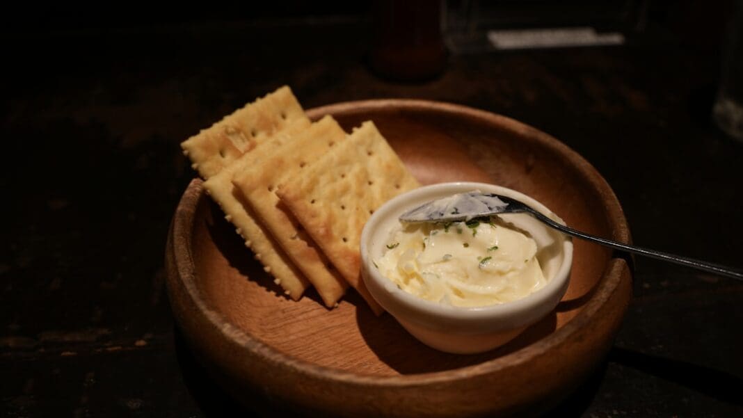 Crackers and dip served in a wooden bowl.