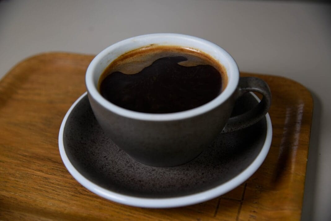 a cup of coffee sitting on top of a wooden tray