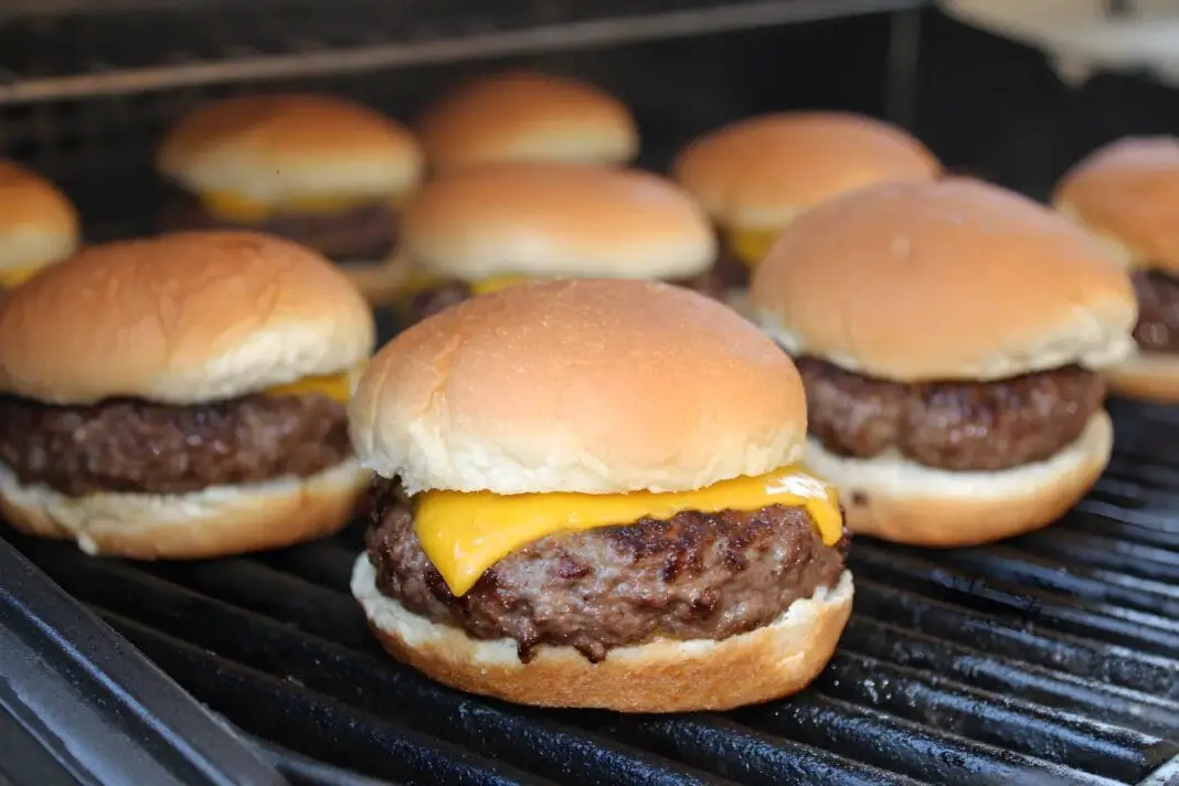 Grilled chuck cheeseburgers, toasted and warm on clean grill grates, with american or sharp cheddar cheese and soft hamburger buns
